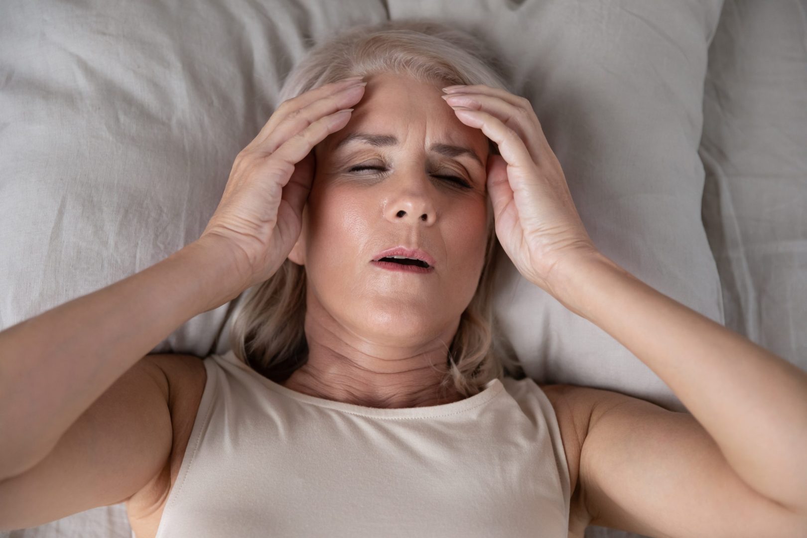 Žena leži sa glavoboljom