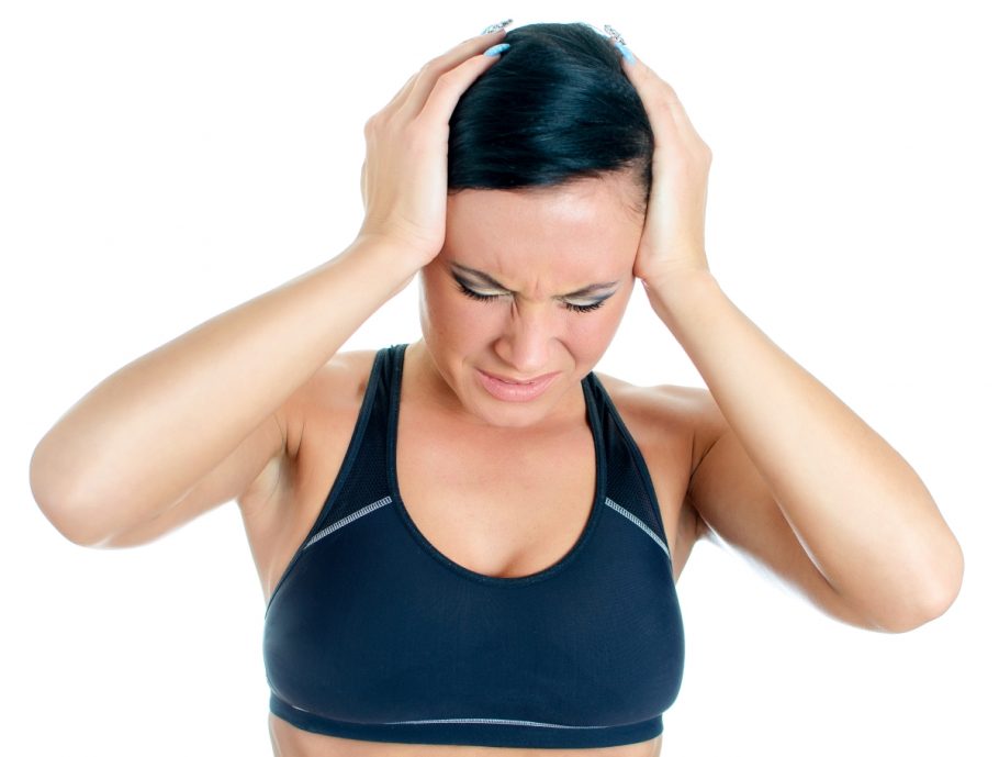 žena koju boli glava tokom vežbanja