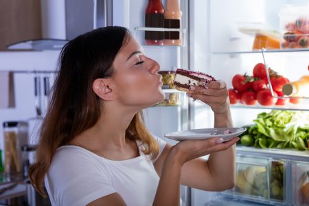 devojka jede pred frižiderom